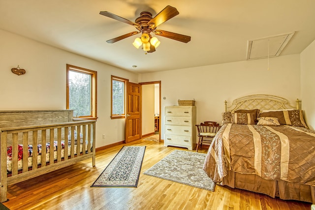 bedroom with attic access, wood finished floors, a ceiling fan, and baseboards