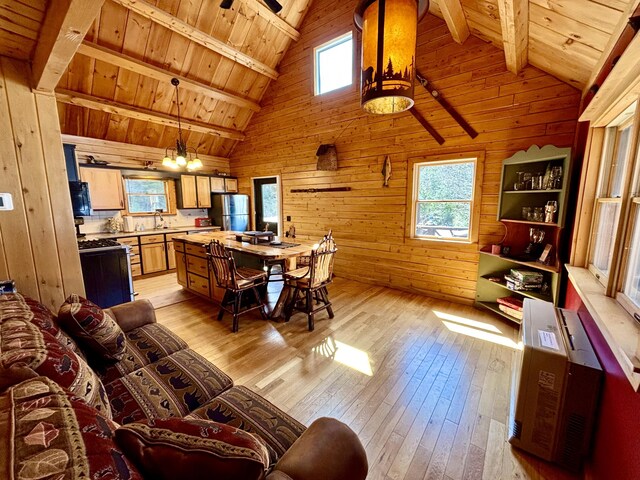 106 N Birch St, Greenville, ME 04441 - living room featuring wooden walls, light wood-style flooring, wood ceiling, beamed ceiling, and plenty of natural light