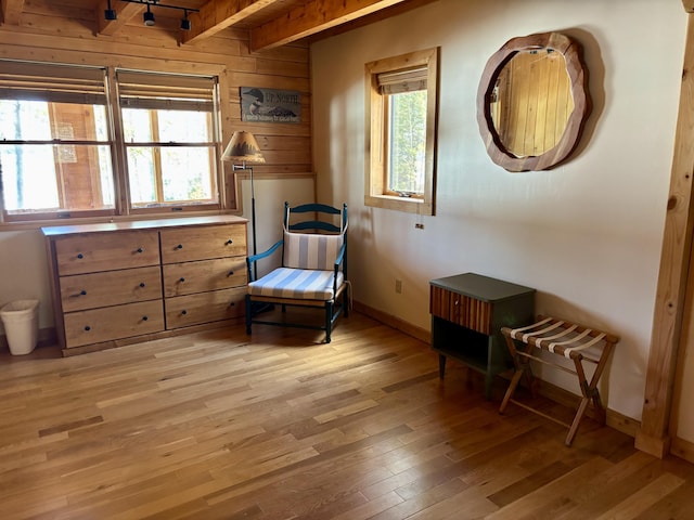 106 N Birch St, Greenville, ME 04441 - living area with light wood-style floors, beam ceiling, baseboards, and wood walls