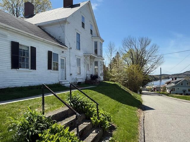 view of home's exterior featuring a chimney, entry steps, and a yard