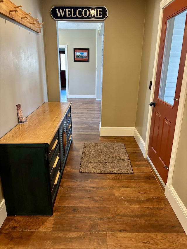 interior space featuring baseboards and dark wood-style floors