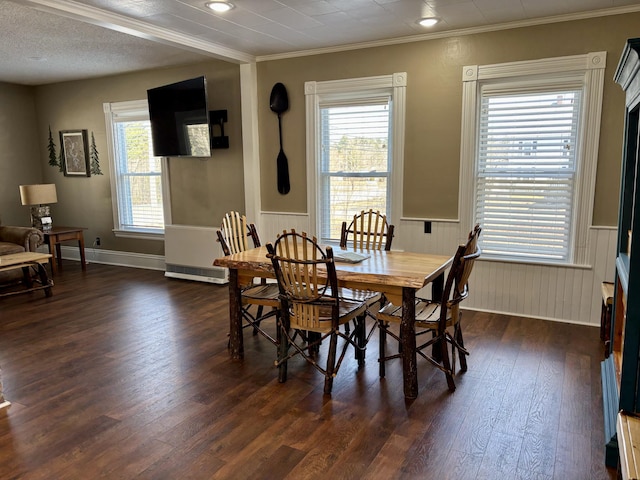 dining room with recessed lighting, dark wood finished floors, crown molding, and wainscoting