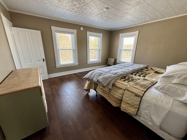 bedroom featuring baseboards, ornamental molding, and dark wood-style floors
