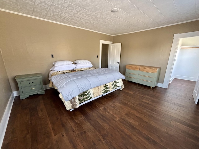 bedroom with baseboards, ornamental molding, and wood finished floors