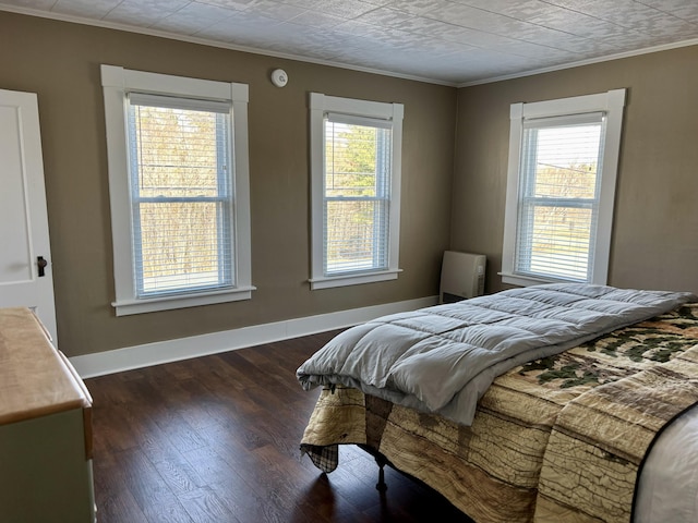 bedroom featuring dark wood-type flooring, baseboards, and ornamental molding
