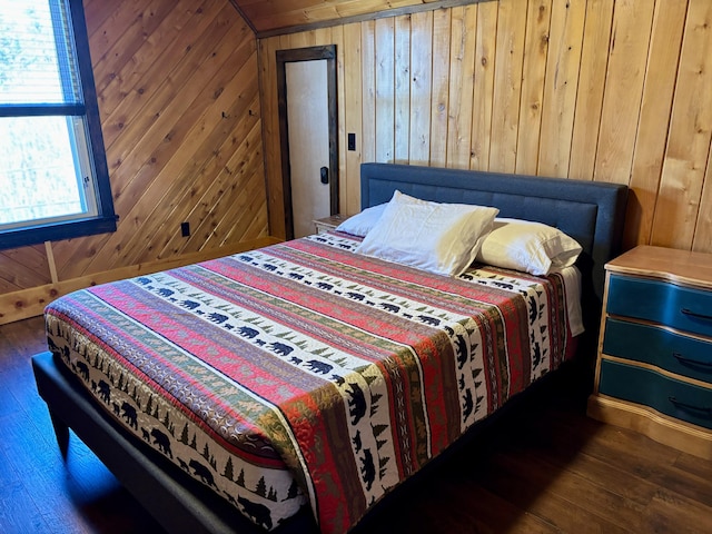 bedroom with wooden walls and hardwood / wood-style flooring