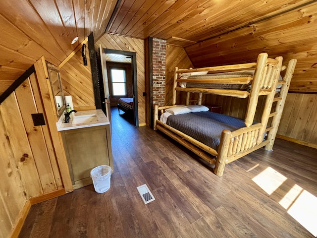 bedroom featuring vaulted ceiling, wood ceiling, visible vents, wood walls, and dark wood-style floors