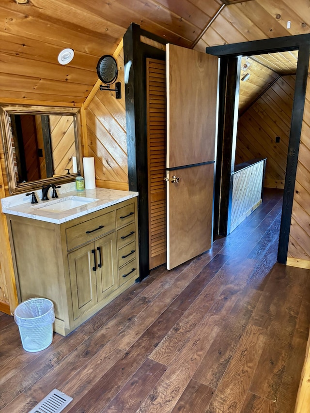 bathroom with wooden ceiling, lofted ceiling, hardwood / wood-style floors, wooden walls, and vanity