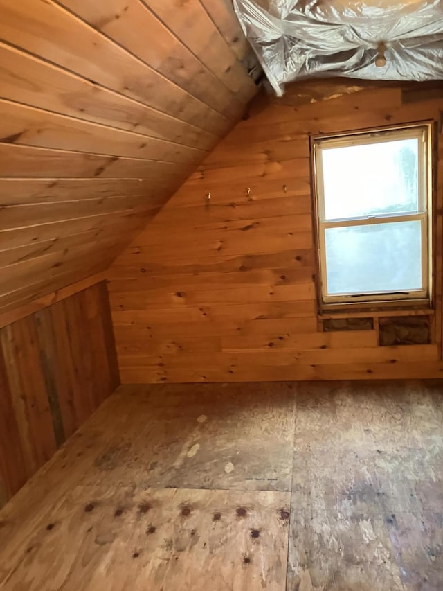additional living space with lofted ceiling, wooden walls, and wooden ceiling