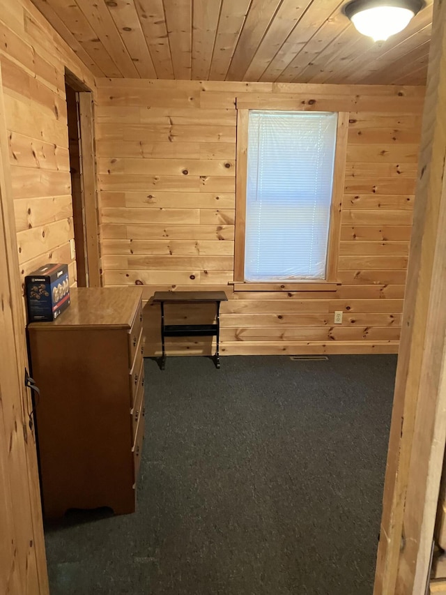 interior space with wooden walls, carpet floors, and wood ceiling