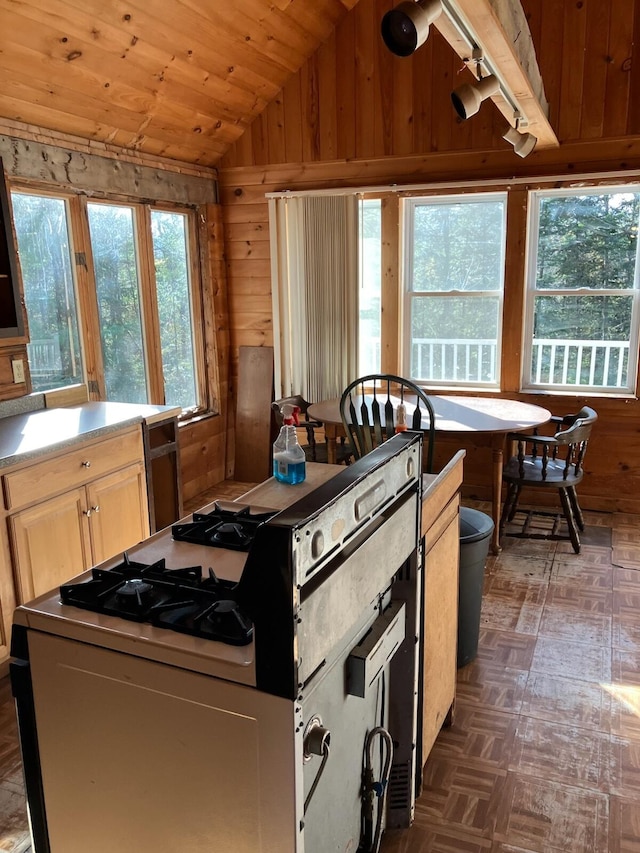 kitchen featuring wood walls, lofted ceiling, wooden ceiling, and range with gas cooktop