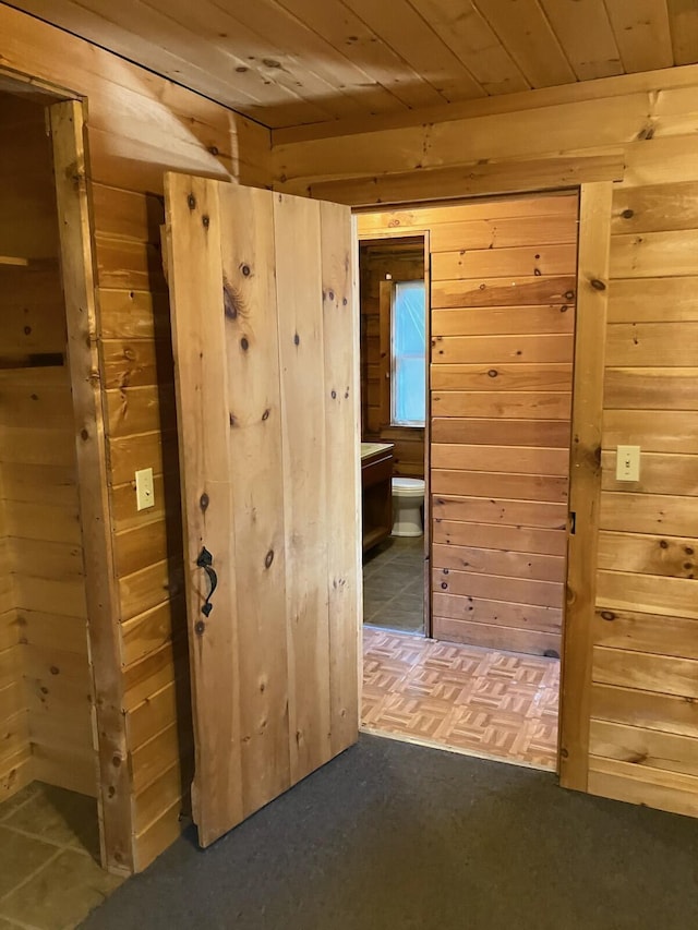 hallway with wood walls and wooden ceiling