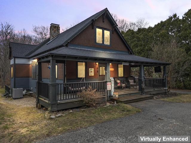 65 Main St, York, ME 03909 - view of front of house with a porch, central AC unit, a shingled roof, and a chimney