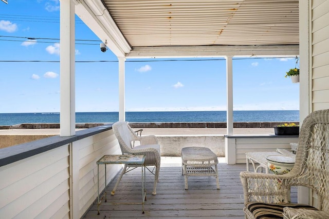 sunroom / solarium featuring hardwood / wood-style floors and a water view