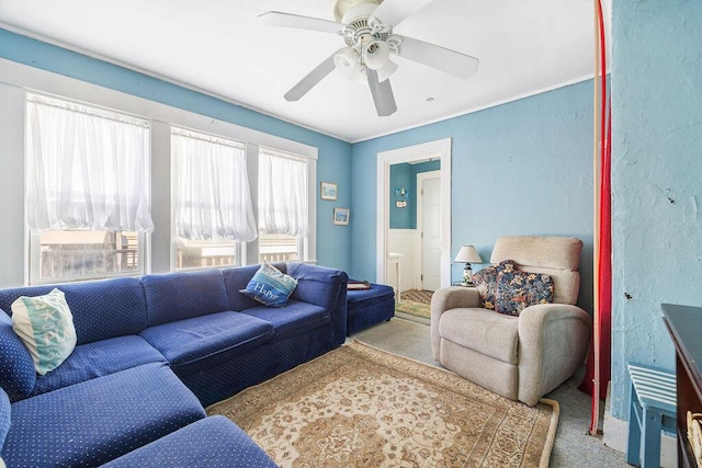 carpeted living area featuring a textured wall and ceiling fan
