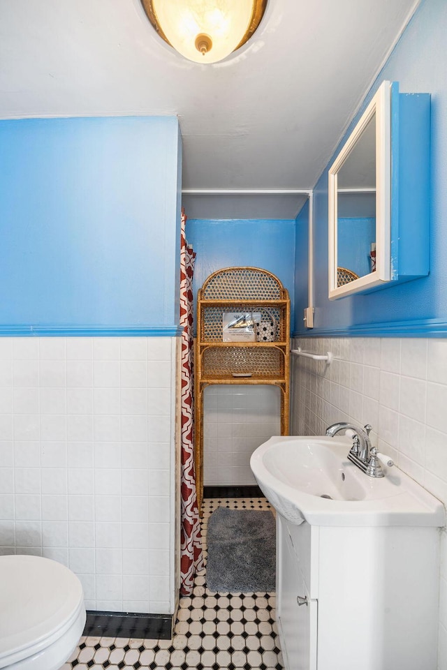 full bathroom featuring toilet, a shower with curtain, vanity, and tile walls