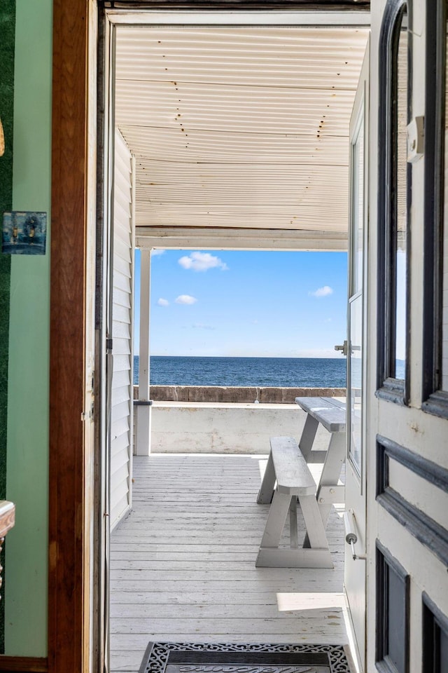 interior space with a beach view, a water view, and wood ceiling