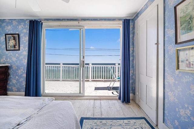 bedroom with multiple windows, wallpapered walls, a ceiling fan, and wood-type flooring