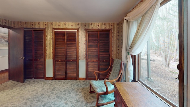 living area with carpet floors, baseboards, and wallpapered walls