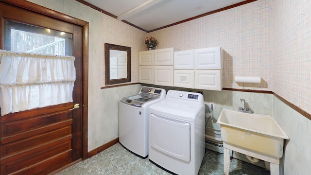 clothes washing area with a sink, washing machine and dryer, laundry area, and crown molding