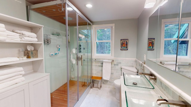 bathroom featuring a shower stall, tile walls, wood finished floors, and a healthy amount of sunlight