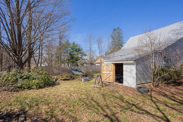 view of yard with fence, an outbuilding, and a storage unit