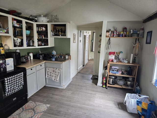 335 Water St, Hallowell, ME 04347 - kitchen with vaulted ceiling, black range with electric stovetop, a textured ceiling, wood finished floors, and open shelves