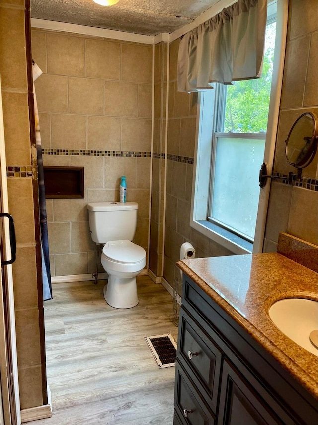 642 Main St, Old Town, ME 04468 - full bath with a textured ceiling, vanity, visible vents, toilet, and wood finished floors