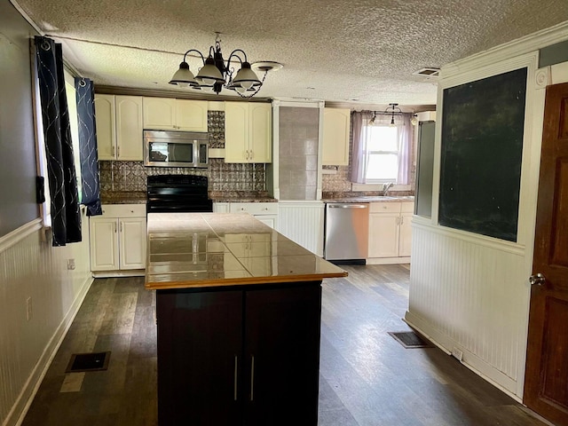 642 Main St, Old Town, ME 04468 - kitchen featuring visible vents, dark wood-style flooring, appliances with stainless steel finishes, a chandelier, and wainscoting