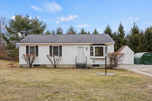 view of front of property with an outbuilding, entry steps, and a front lawn