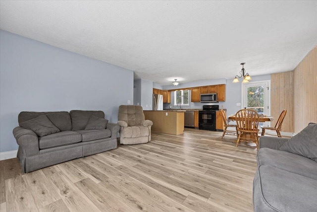 living area featuring light wood-style flooring and a notable chandelier