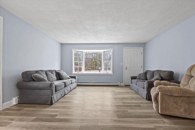 living room featuring baseboards, a baseboard radiator, a textured ceiling, and wood finished floors