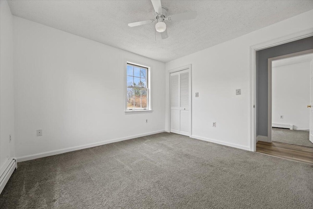 unfurnished bedroom featuring a closet, baseboards, a textured ceiling, baseboard heating, and carpet flooring