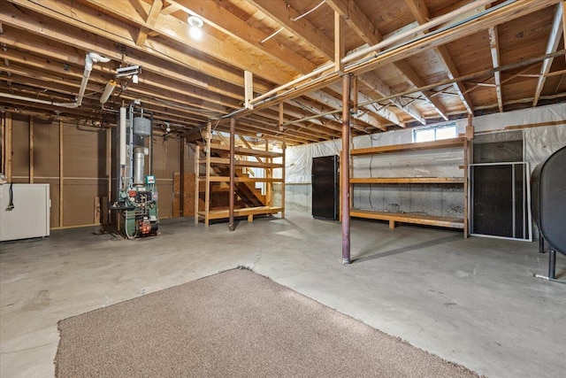 basement with washer / dryer, a heating unit, and heating fuel
