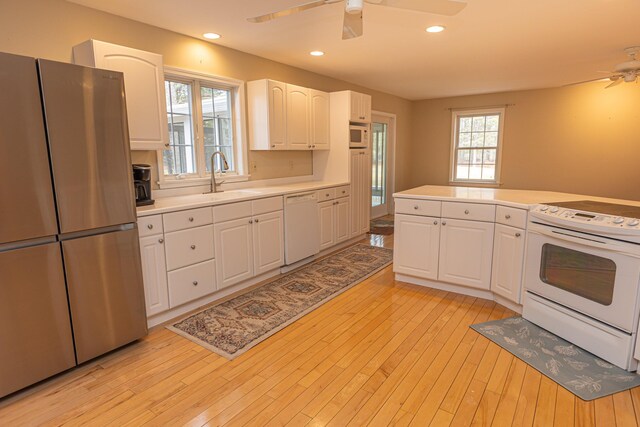 21 Oakmont Dr Unit 21, Old Orchard Beach, ME 04064 - kitchen featuring white cabinets, white appliances, a sink, and ceiling fan
