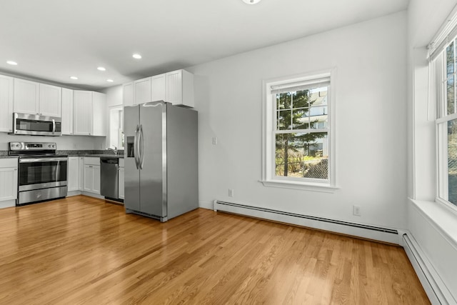 kitchen with a baseboard radiator, plenty of natural light, a baseboard heating unit, and stainless steel appliances