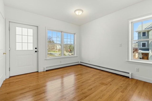 interior space with light wood finished floors and a baseboard heating unit