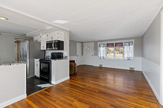 kitchen featuring visible vents, white cabinets, dark wood-style flooring, open floor plan, and stainless steel appliances
