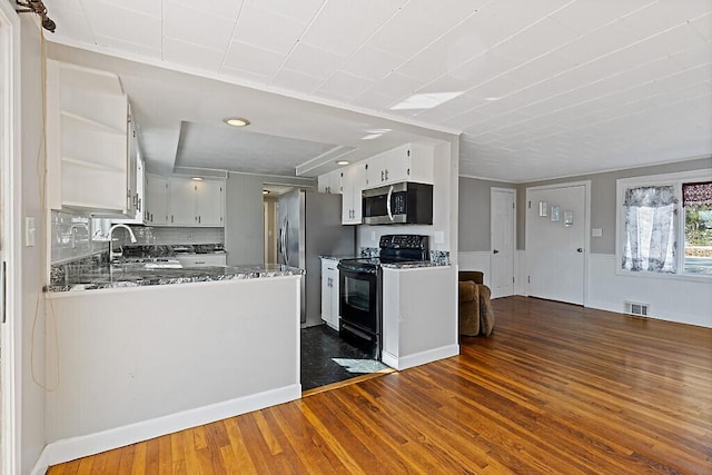 kitchen featuring appliances with stainless steel finishes, open shelves, visible vents, dark wood finished floors, and a sink