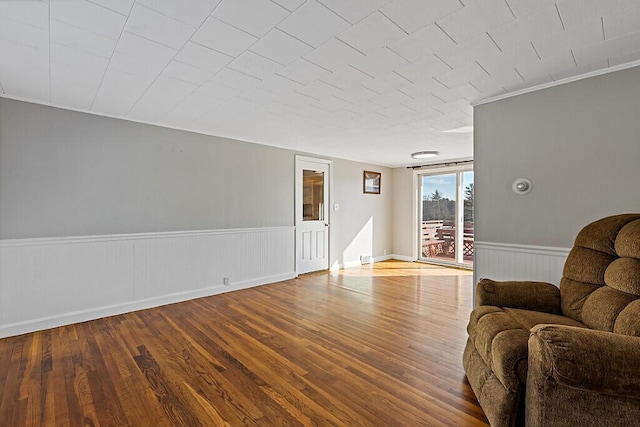 living room featuring wood finished floors and a wainscoted wall