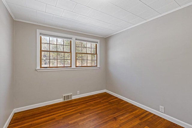 unfurnished room featuring dark wood-type flooring, baseboards, and visible vents