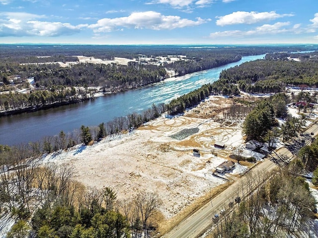 aerial view featuring a forest view and a water view