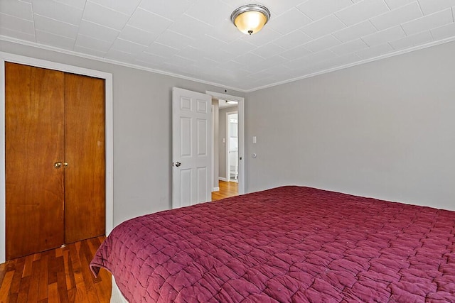 bedroom featuring crown molding and wood finished floors