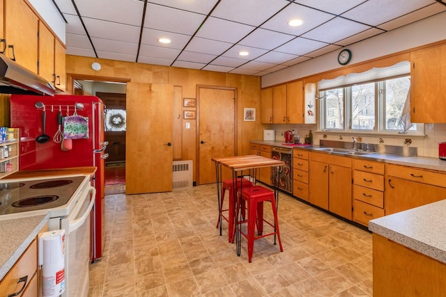 kitchen featuring stainless steel counters, white electric range, wine cooler, a drop ceiling, and a sink