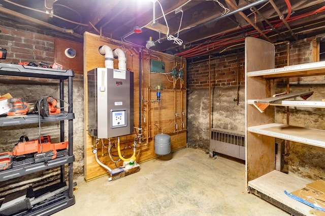 unfinished below grade area featuring radiator heating unit and water heater