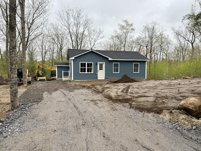 view of front of house featuring a shingled roof and driveway