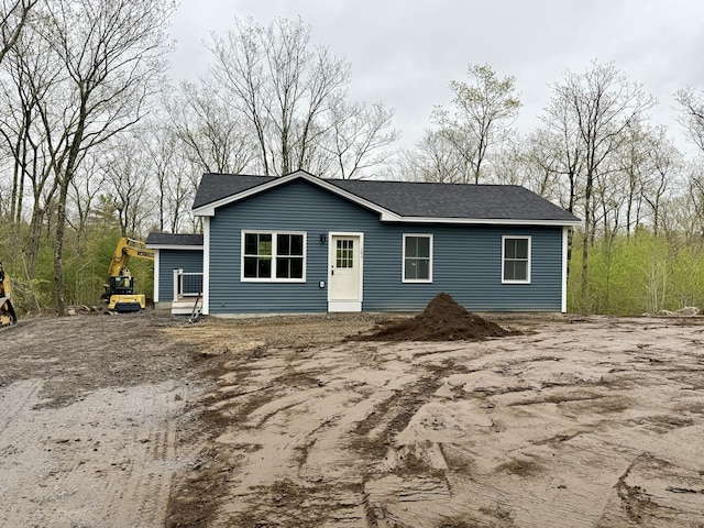 back of house with a shingled roof