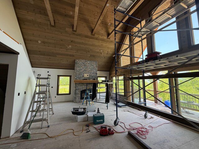 46 Harmony Row, Bethel, ME 04217 - unfurnished living room with high vaulted ceiling, wooden ceiling with exposed beams, and a stone fireplace