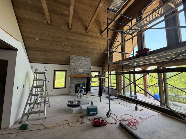46 Harmony Row, Bethel, ME 04217 - unfurnished living room with high vaulted ceiling, wooden ceiling with exposed beams, and a stone fireplace