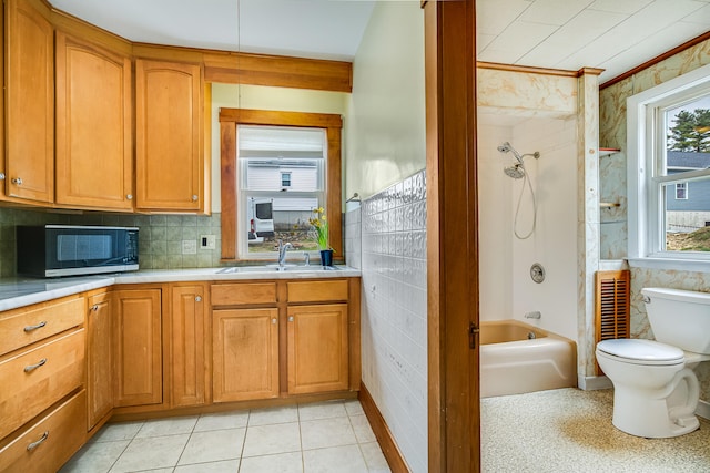 interior space with shower / bathtub combination, toilet, vanity, and decorative backsplash